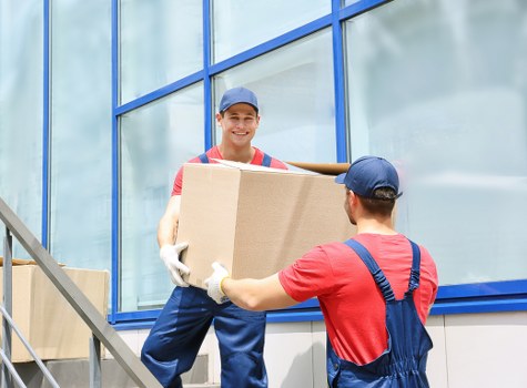 Specialist piano removals team preparing an upright piano for transport in Edgware